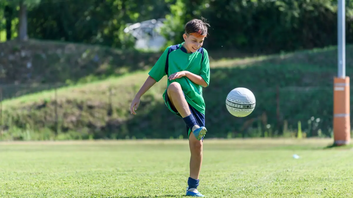 Un jeune joueur contrôlant le ballon sur un terrain de football